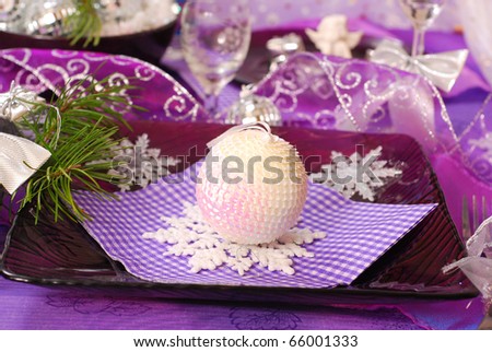 glamour christmas table decoration in purple color with shining ball and snowflakes on glass plate