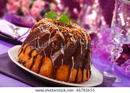 chocolate ring cake with nuts topping for party on purple shining background