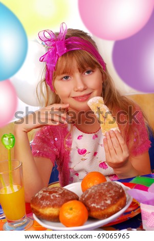 happy young girl eating cookies on the party