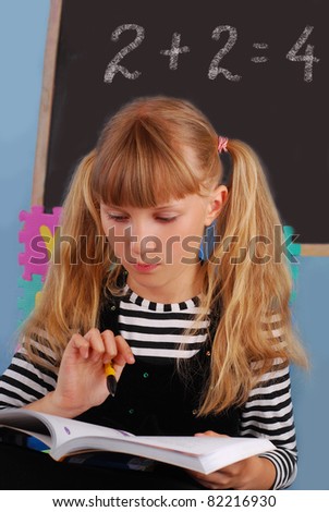 schoolgirl in the classroom learning on mathematics lesson