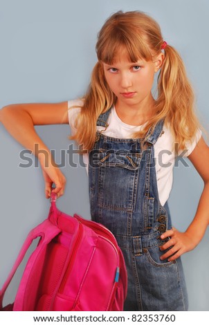 angry schoolgirl with pink backpack against blue background