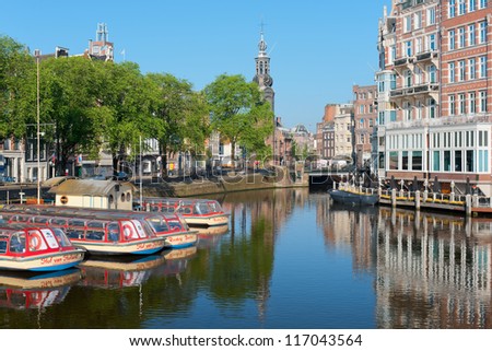 AMSTERDAM, NETHERLANDS - MAY 28: Sightseeing boats on a canal on May 28, 2012 in Amsterdam. Having a population of more than 750,000  Amsterdam is visited with over 3,5 million foreign visitors a year