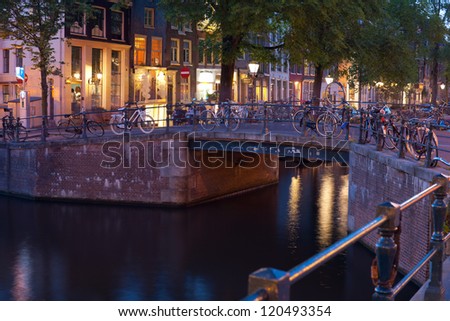 AMSTERDAM, NETHERLANDS - MAY 27: Bicycles on the bridge over an Amsterdam canal at night on May, 27, 2012 in Amsterdam. More than 60% of trips in the center of Amsterdam are made by bike.