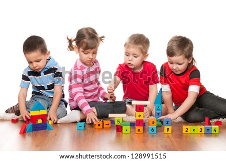 Four kids are playing on the floor with blocks Four kids are playing on the floor with blocks