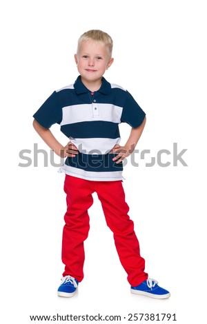 A portrait of a handsome little boy in the red pants on the white background