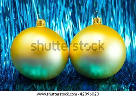 Yellow Christmas baubles on a shiny blue glitter background