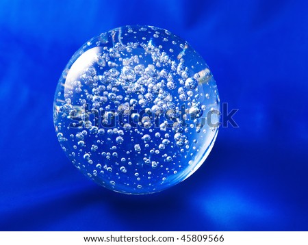 Transparent glass ball with air bubbles inside on a blue background