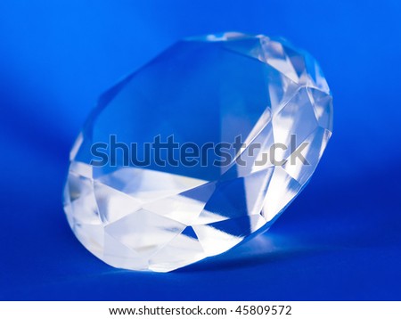 Transparent clear crystal gemstone on a blue background
