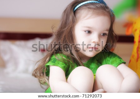 little girl hugging her knees so sad