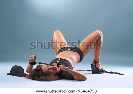 Beautiful sexy girl police pistol and handcuffs, on a blue background