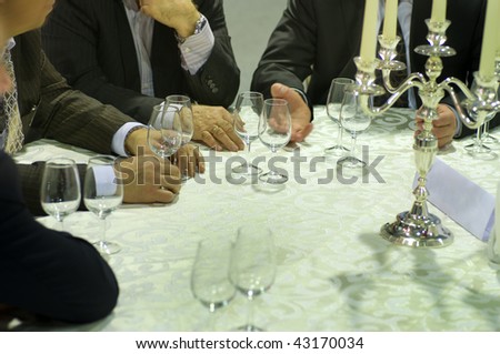 Behind a round table covered with a white cloth of the man wine tasting expect.