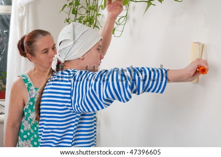 The grandmother and the grand daughter together do face lifting on kitchen