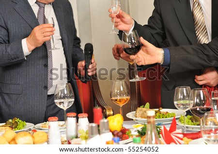 Men on a corporate party at restaurant drink alcoholic drinks.