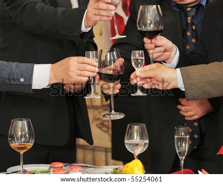 Men on a corporate party at restaurant drink alcoholic drinks.
