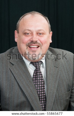 The cheerful man at the age of fifty years in a grey suit.