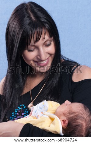 The happy woman shining with happiness holds on hands of the first child.