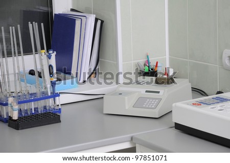 In hospital laboratory the blood analyzer, glass beakers and log-books on a window sill.
