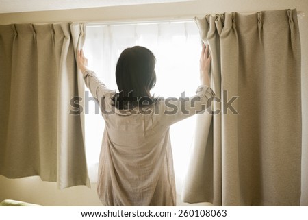 The woman who opens a curtain
