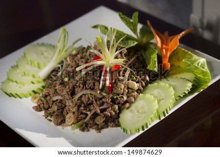 Beef larb mixed with rice powder, chili powder, onion and fresh herbs
