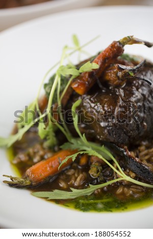 Braised beef short ribs with burnt carrots, toasted faro and carrot top vinaigrette