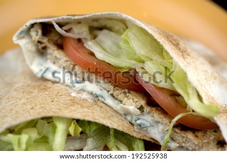 Chicken Shawarma. Pita bread filled with shawarma seasoned grilled chicken, beef, or lamb patty topped with lettuce, tomatoes, onions, pickles, parsley and tahini sauce