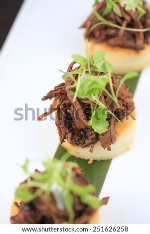 Beef arepa with white corn cake, pulled brisket and chili verde crema