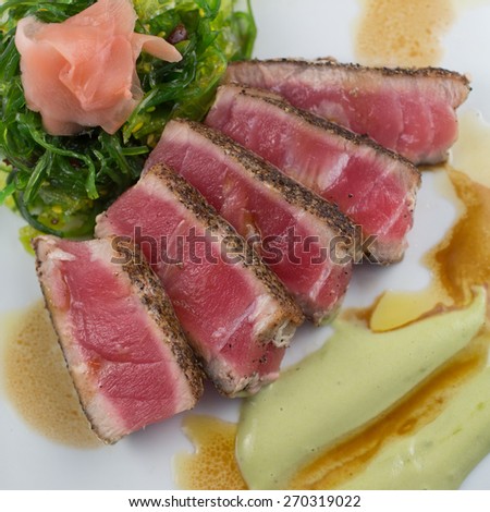 SEARED TUNA Peppercorn crusted seared tuna with seaweed salad, pickled ginger, wasabi aioli and soy balsamic drizzle