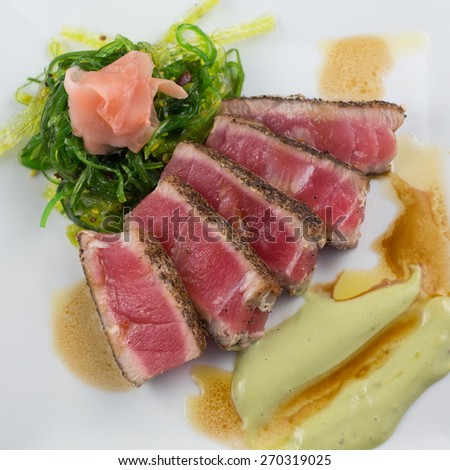 SEARED TUNA Peppercorn crusted seared tuna with seaweed salad, pickled ginger, wasabi aioli and soy balsamic drizzle