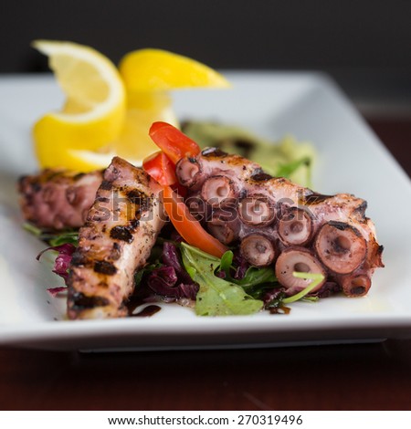 GRILLED OCTOPUS. Grilled octopus served with avocado puree and lemon oil