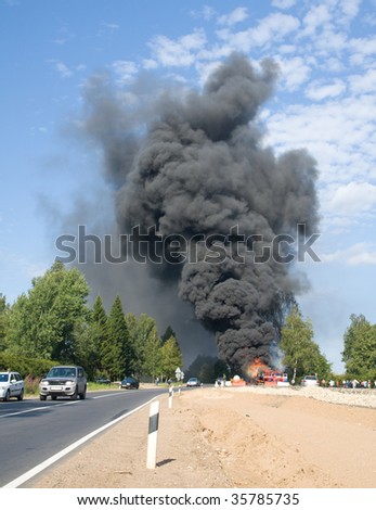 truck in fire with black smoke on the road