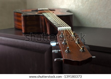 brown six-string acoustic guitar lying on the table