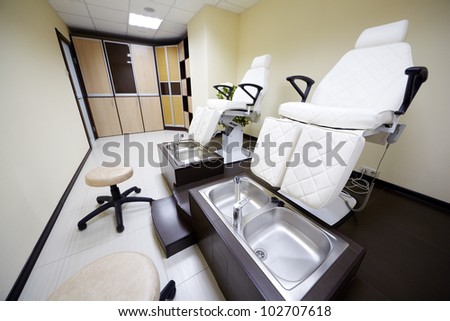 Two armchairs, bathtubs, chairs and wardrobes in the pedicure cabinet in the beauty salon.