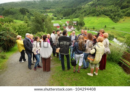 NORDDAL - JUNE 26: Russian tourists stand on hill and listen guide on JUNE 26, 2011 in Norddal, Norway. In 2011 Norway issued to Russian citizens 30 236 visas, 65% of visas were tourist.