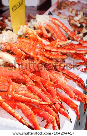 Fresh red king-crab legs in ice at seafood market; cabs high content protein and low calorie