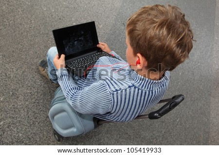 one boy watches movie on laptop until train coming