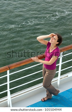 young woman in red blouse travel on ship looks at sky