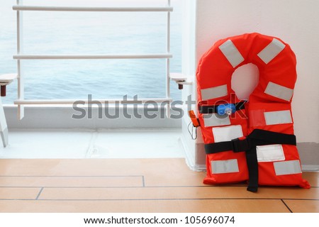 One orange life jacket stands on deck of cruise passenger liner