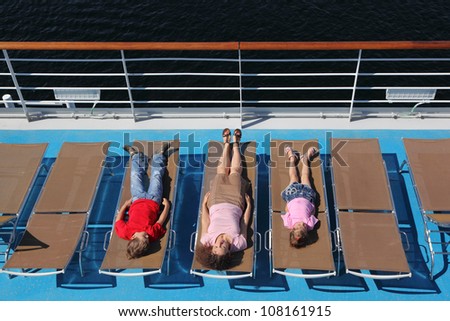 Top view of mother, son and little daughter lying at deck-chair on ship