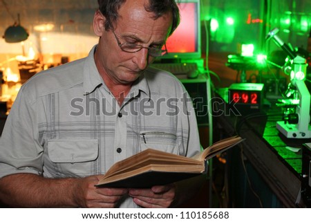 Scientist with glass read book in his lab of movement of microparticles by laser