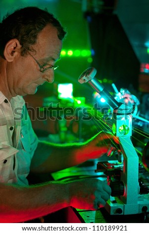 Scientist engaged in research in his lab show movement of microparticles by laser