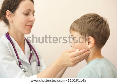 Doctor checks little boy lymph nodes, focus on boy
