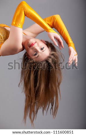 long hair of red lips model in yellow shine dress hang down in photo studio, halfbody