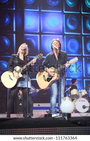 MOSCOW - DEC 17: Chris Norman sings with woman play on guitar on scene during concert of Legend RetroFM in Sports complex Olimpiyskiy, Dec 17, 2011, Moscow, Russia. Chris Norman sing duet with woman.