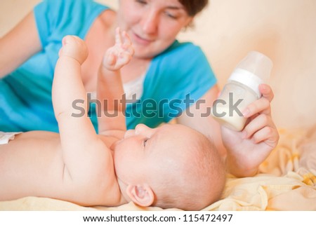 Mom  feed  baby with bottle, play in bed
