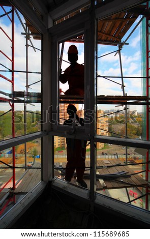 Workers install plastic windows in new building