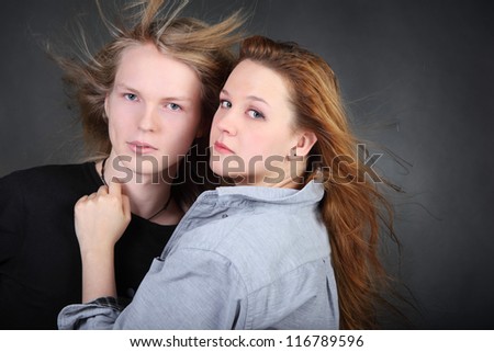 brown hair woman in shirt hug long hair boy in photo studio, half body