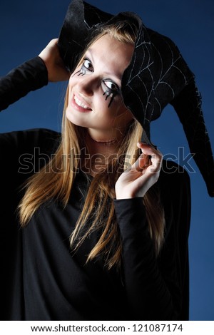 Smiling zombie girl with black tears and cut throat in big black hat.