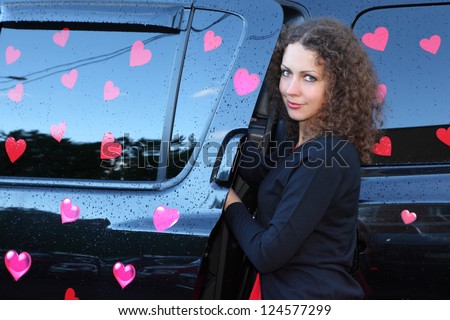 Young beautiful woman gets in black wet  offroader with stickers hearts. Pink wedding.