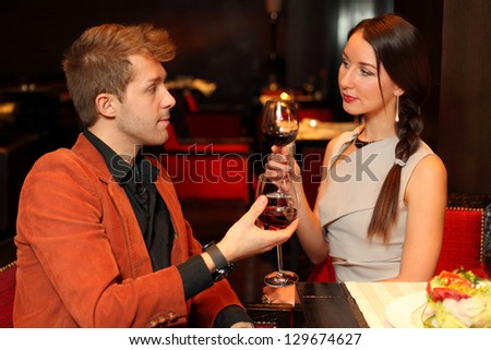 Man and woman with a glass of wine looking lovingly into the eyes