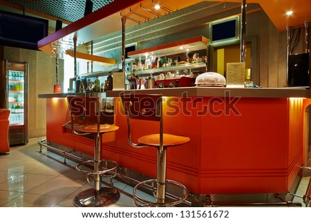 Bar Counter And Barstools In Empty Cafe-Bar With Orange Interior
